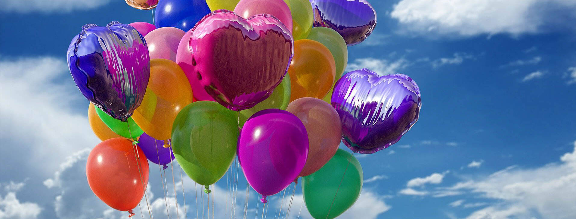 Bunte Luftballons steigen in den Himmel.